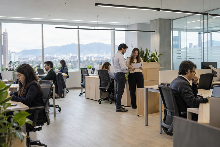 Profesionales trabajando en una oficina abierta con vista a las montañas